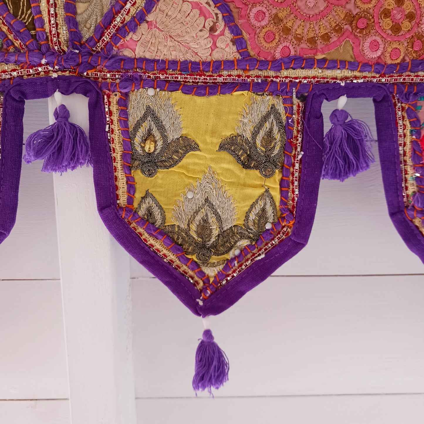 This long and beautifully intricate Indian Toran has been handmade from patches of vintage fabrics, wedding saris and recycled fabrics. It will be a unique addition to any home and bring vibrancy of colour and embellishment.