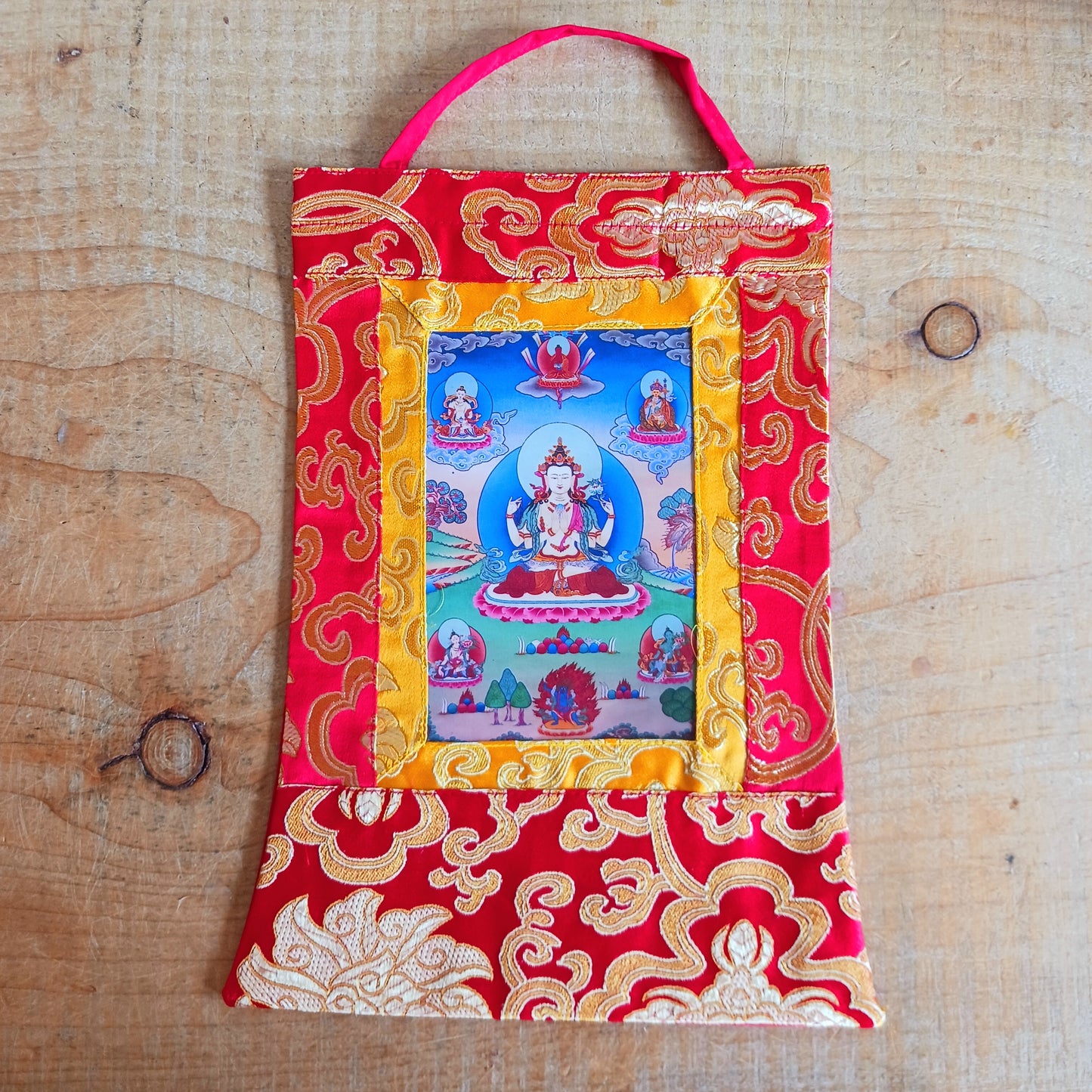 Shop this small Chenrezig thangka with silk brocade frame – a sacred image of Avalokiteshvara, the Bodhisattva of Compassion. Perfect for altars or gifting.