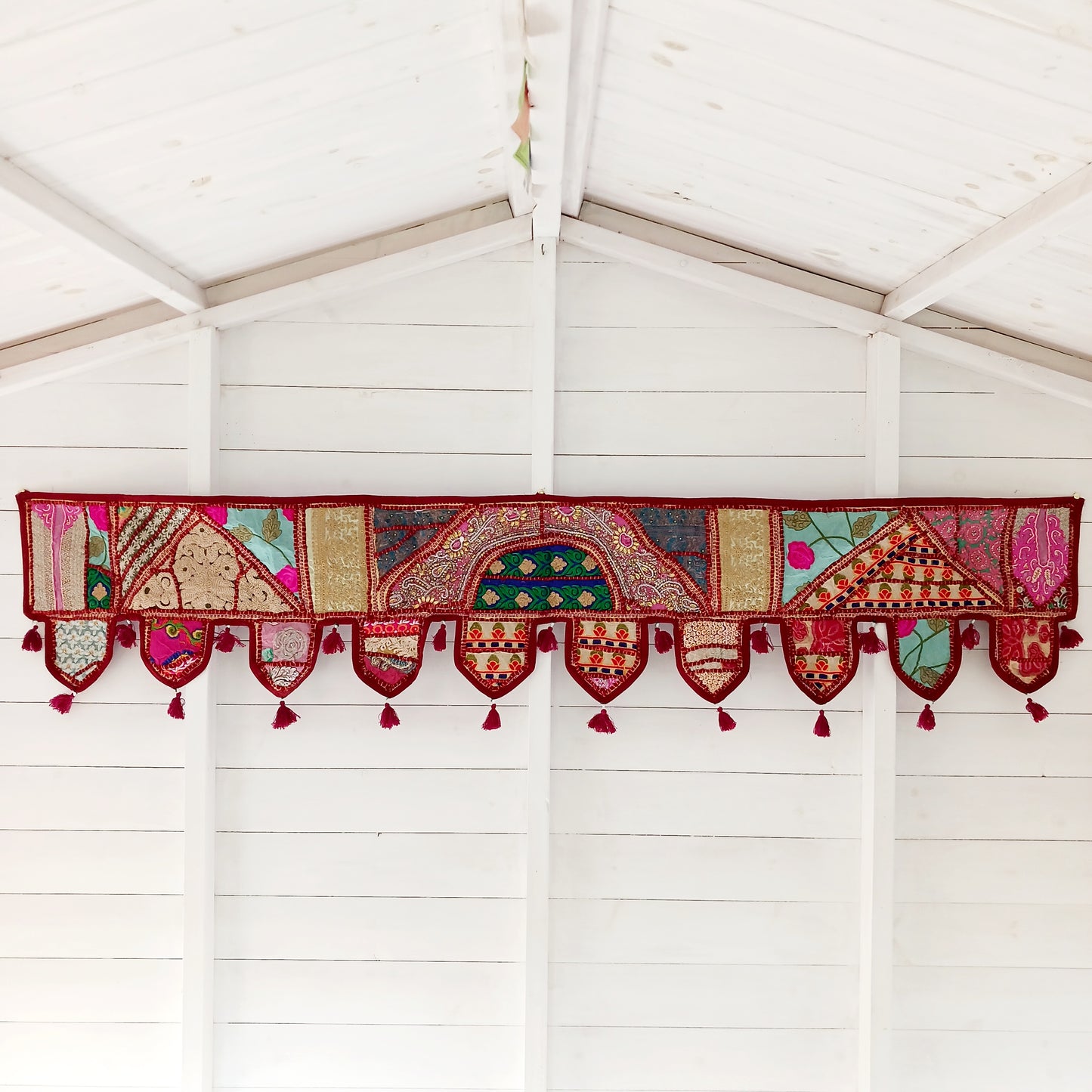 This long and beautifully intricate Indian Toran has been handmade from patches of vintage fabrics, wedding saris and recycled fabrics.  It will be a unique addition to any home and bring vibrancy of colour and embellishment.