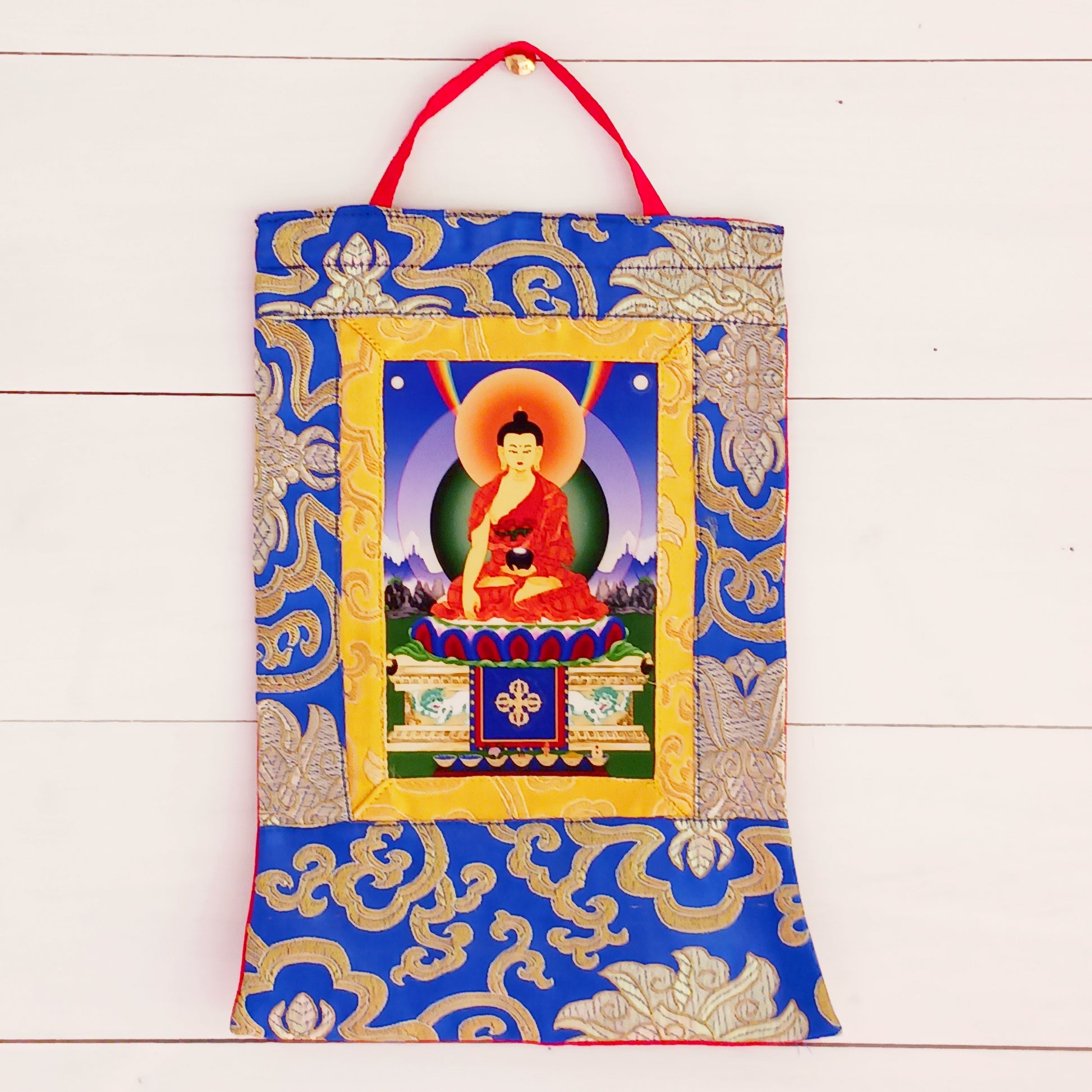 Beautiful small thangka of Shakyamuni Buddha with brocade border. A perfect spiritual art piece for meditation or home altar decoration.