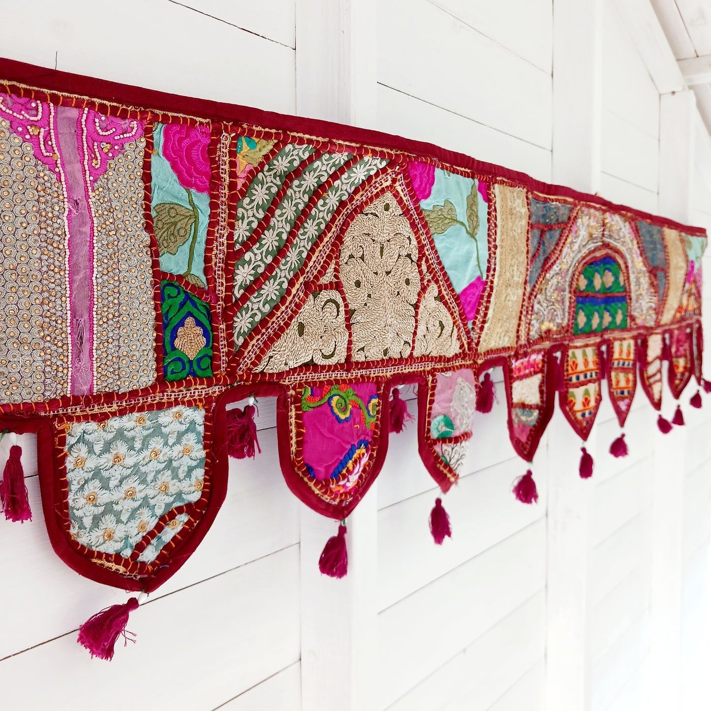 This long and beautifully intricate Indian Toran has been handmade from patches of vintage fabrics, wedding saris and recycled fabrics.  It will be a unique addition to any home and bring vibrancy of colour and embellishment.