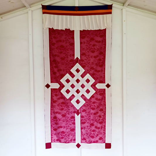 Bring spiritual harmony and traditional Himalayan craftsmanship into your home with this handmade Tibetan Buddhist Endless Knot Door Curtain. Crafted in a rich maroon fabric, this semi-transparent curtain allows natural light to pass through, creating a warm and calming atmosphere.