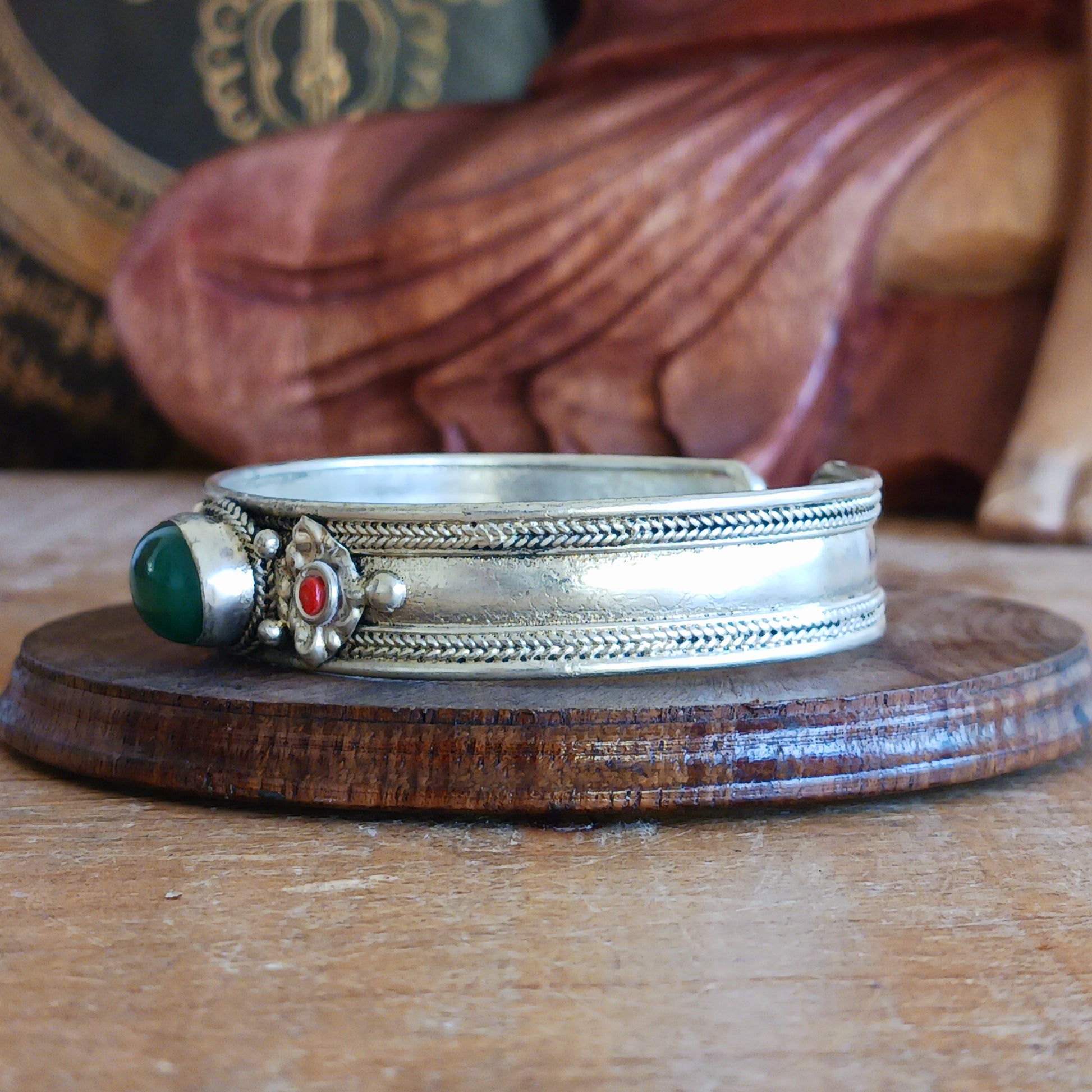 Add a touch of elegance and meaning to your jewellery collection with this handcrafted Nepalese bangle. Made from high-quality white metal, each bangle features a single green aventurine stone, symbolizing luck and harmony, flanked by two vibrant red drop beads for a striking contrast.