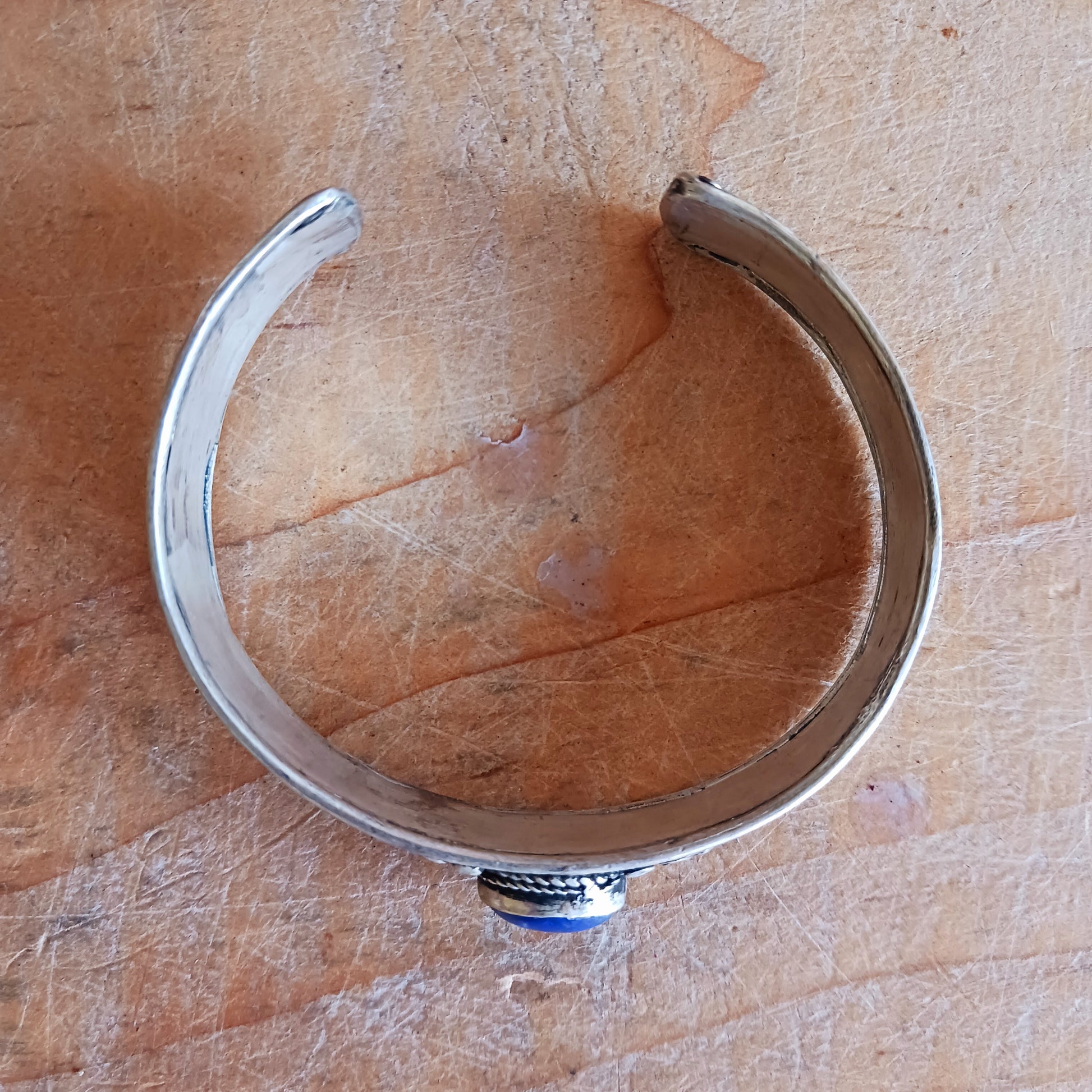 These beautifully handcrafted Nepalese white metal bangles feature a striking central lapis stone, delicately flanked by two drop coral beads. Each piece is individually made by skilled artisans in local Nepalese workshops, ensuring no two bangles are ever exactly alike.