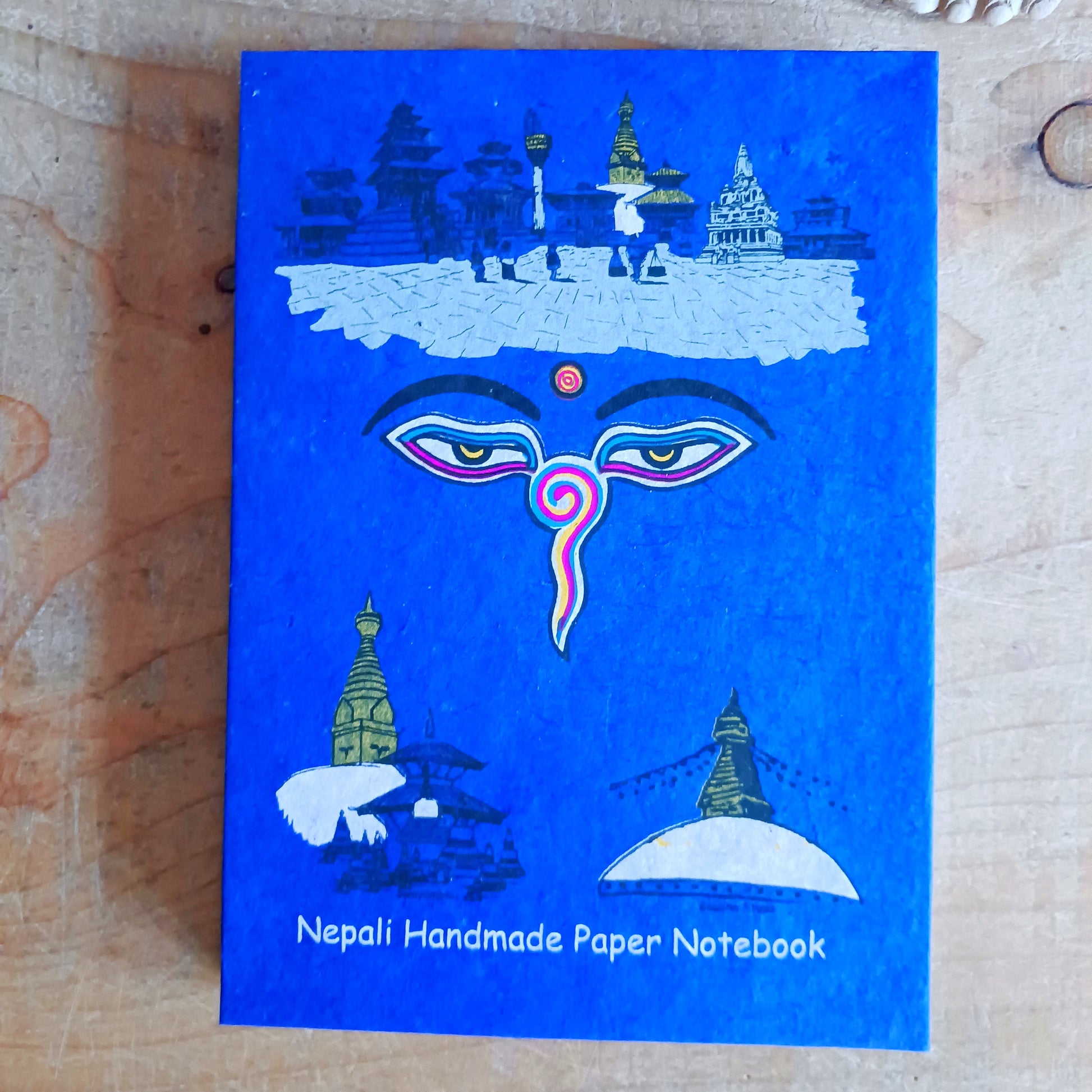 Experience the beauty of traditional Nepalese craftsmanship with this Buddha | Wisdom Eyes Notebook, handcrafted from natural Lokta paper. Each notebook features a durable hardback cover and approximately 50 pages of acid-free, eco-friendly Lokta paper, making it perfect for writing, sketching, journaling, or preserving important scripts for long periods.