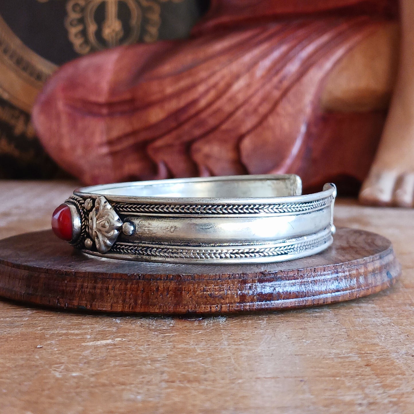 Add a touch of elegance and meaning to your jewellery collection with this handcrafted Nepalese bangle. Made from high-quality white metal, the bangle features a single coral stone.