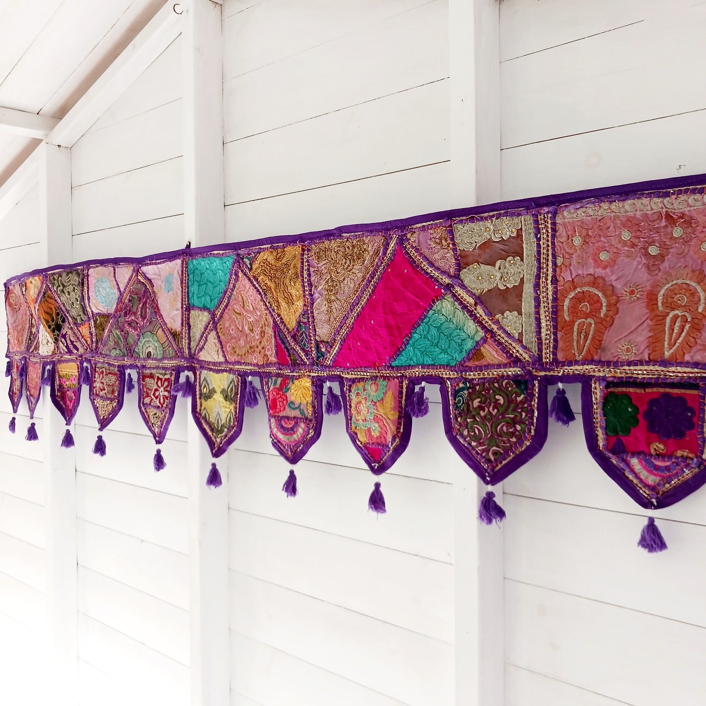This long and beautifully intricate Indian Toran has been handmade from patches of vintage fabrics, wedding saris and recycled fabrics. It will be a unique addition to any home and bring vibrancy of colour and embellishment.