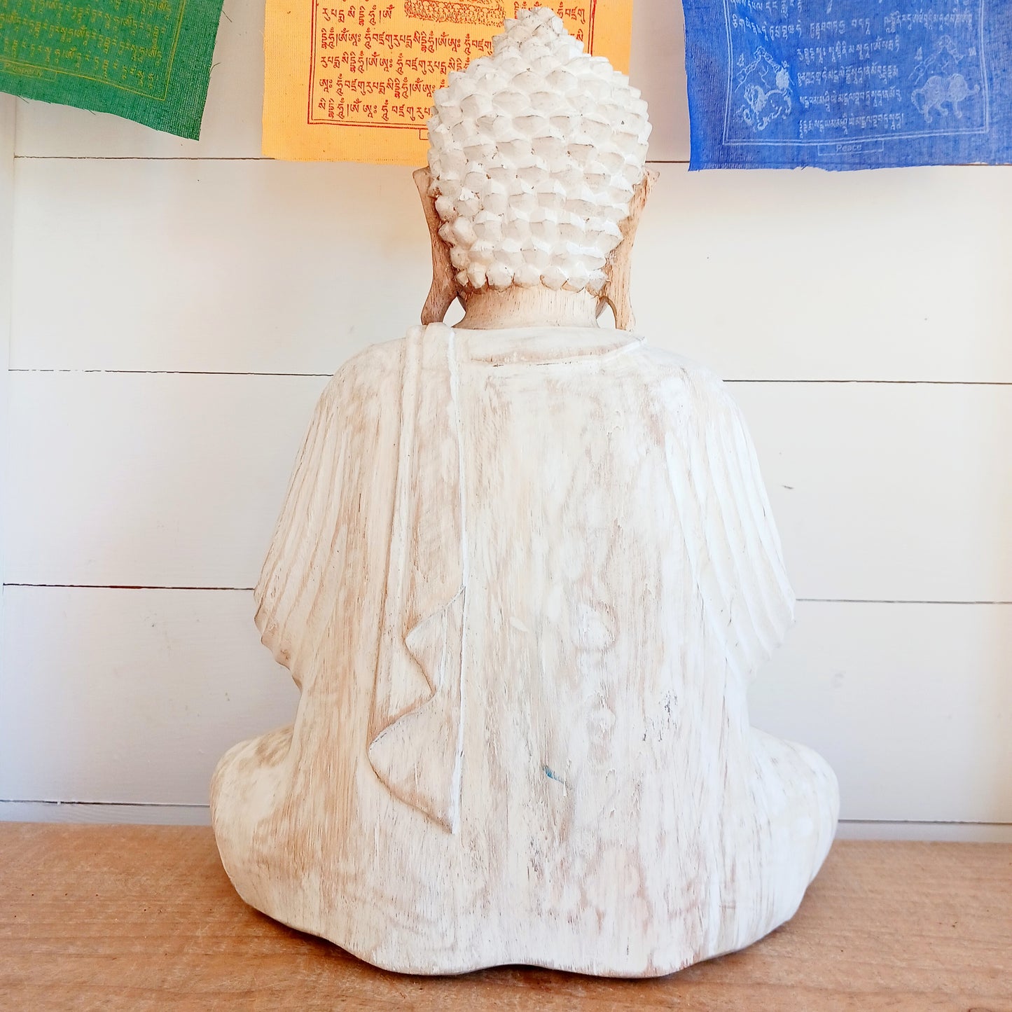 Bring calm, wisdom, and mindful intention into your space with this beautifully serene Teaching Buddha statue, hand-carved from sustainable Suar wood (Albizia Saman), a fast-growing and responsibly cultivated hardwood, finished in whitewash.